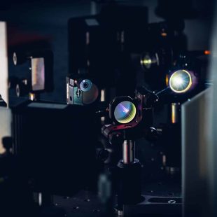 Experiment with laser device in optical laboratory.